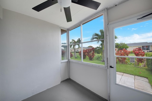 unfurnished sunroom featuring ceiling fan