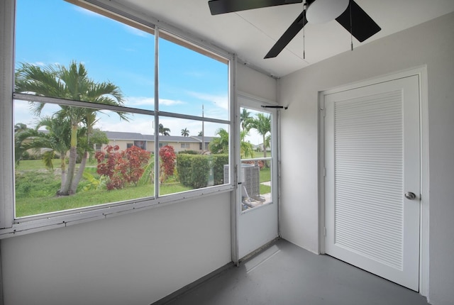 unfurnished sunroom with ceiling fan