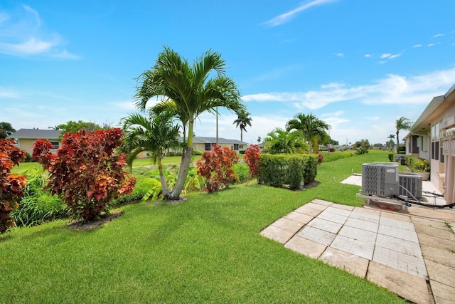 view of yard with central AC and a patio area