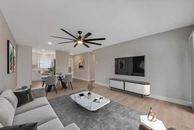 living room featuring light hardwood / wood-style flooring and ceiling fan