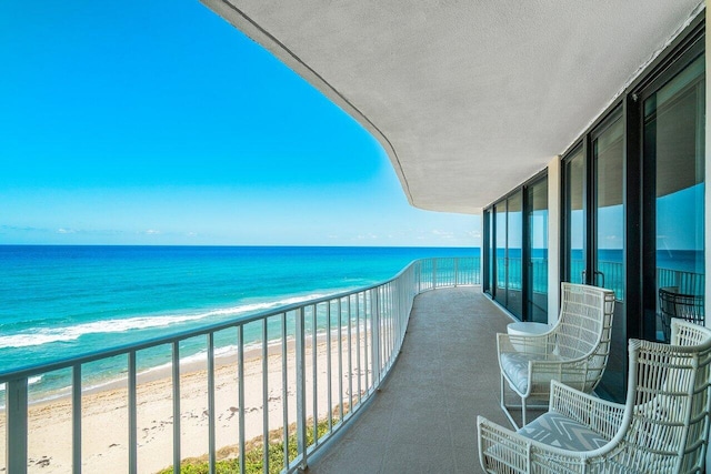 balcony with a beach view and a water view