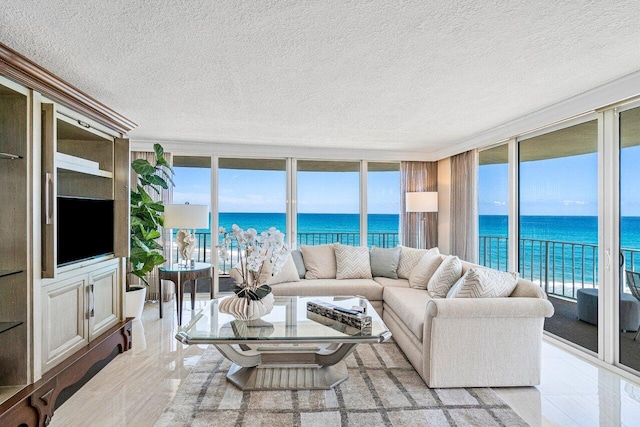 tiled living room with expansive windows, a water view, and a textured ceiling