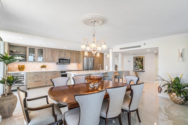 dining area featuring light tile patterned floors, a textured ceiling, a chandelier, beverage cooler, and ornamental molding