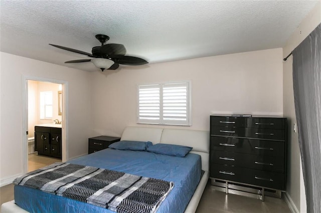 bedroom featuring sink, ceiling fan, a textured ceiling, and ensuite bathroom