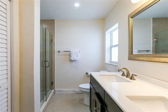 bathroom featuring vanity, an enclosed shower, toilet, and tile patterned floors