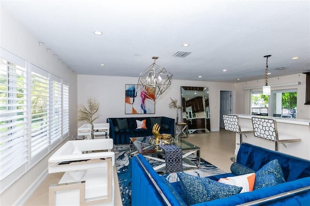 living room featuring a notable chandelier and concrete floors