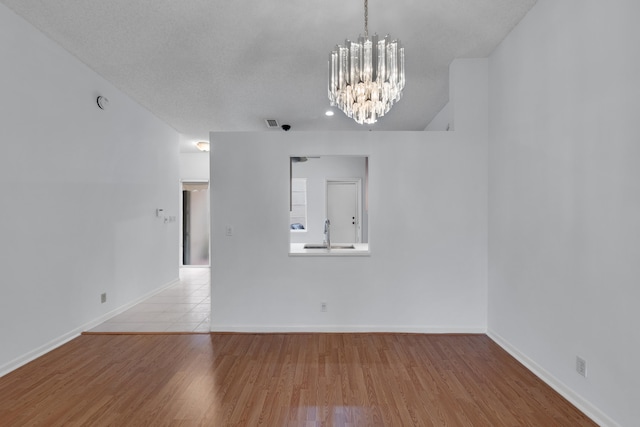 tiled empty room with sink and a chandelier