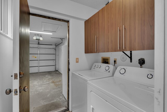 laundry area with washer and clothes dryer and cabinets