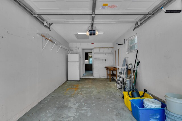 garage with white refrigerator and a garage door opener