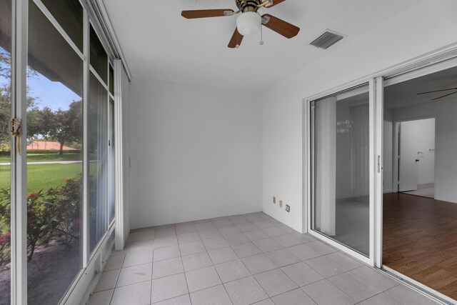 unfurnished sunroom featuring ceiling fan