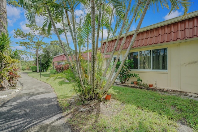 view of side of home with a yard