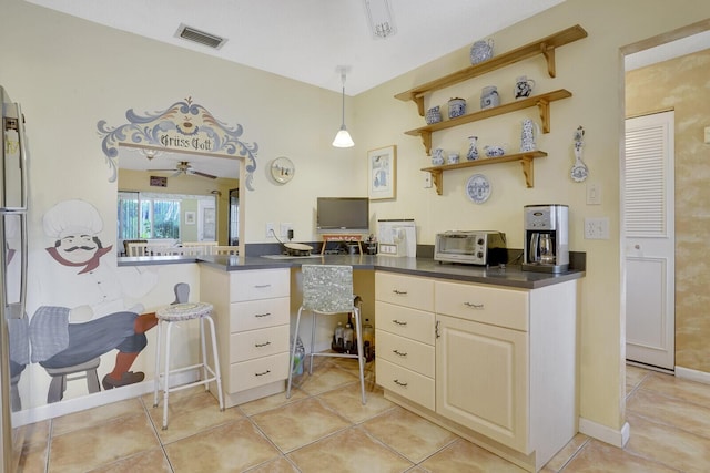 kitchen with light tile patterned flooring, ceiling fan, and stainless steel refrigerator