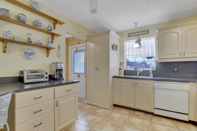 kitchen with dishwasher, plenty of natural light, sink, and light tile patterned floors