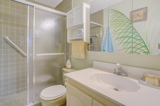 bathroom with vanity, toilet, and a shower with shower door