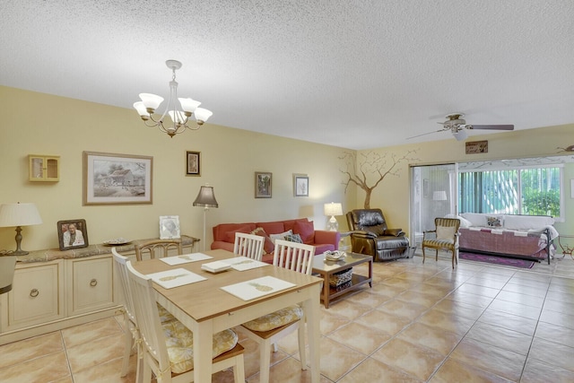 tiled dining space featuring ceiling fan with notable chandelier and a textured ceiling