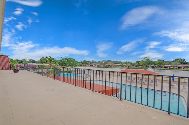 view of swimming pool featuring a patio area and a water view