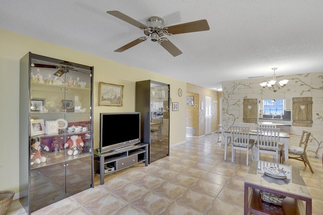 living room featuring ceiling fan with notable chandelier and a textured ceiling