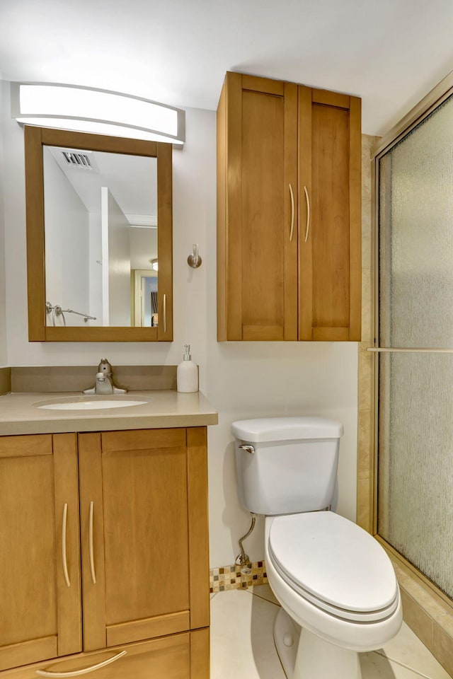 bathroom featuring a shower with door, tile patterned floors, vanity, and toilet