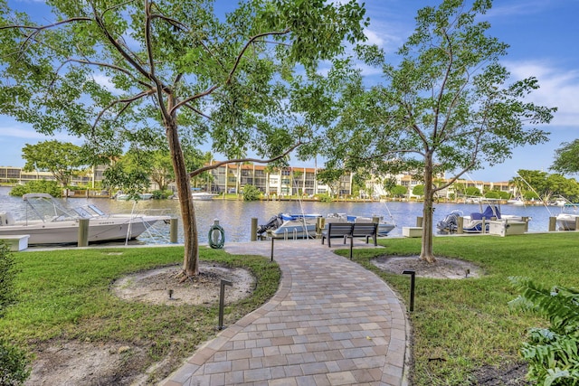 view of home's community featuring a boat dock, a lawn, and a water view