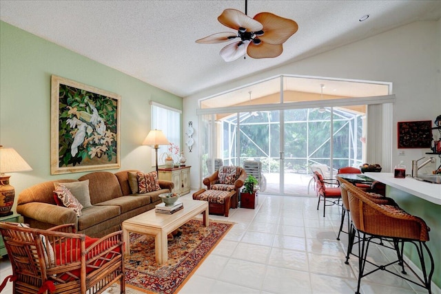 tiled living room with a textured ceiling, ceiling fan, and vaulted ceiling