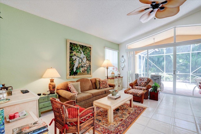 living room with a textured ceiling, ceiling fan, vaulted ceiling, and light tile patterned floors