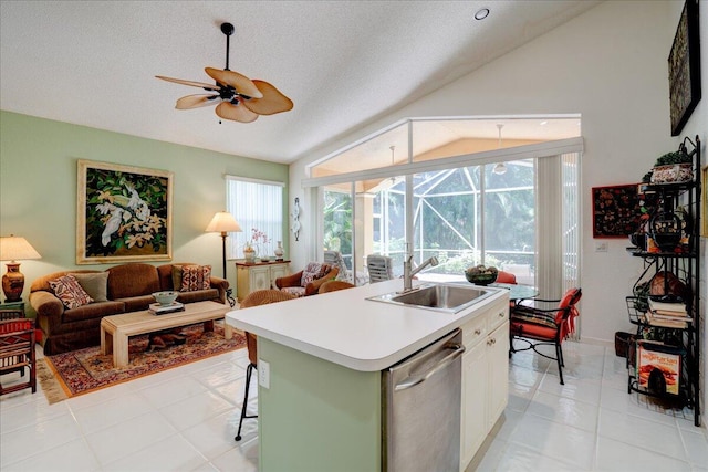 kitchen with stainless steel dishwasher, ceiling fan, sink, lofted ceiling, and light tile patterned floors