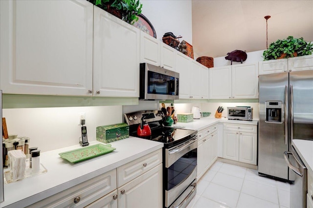 kitchen featuring light tile patterned floors, white cabinets, and stainless steel appliances