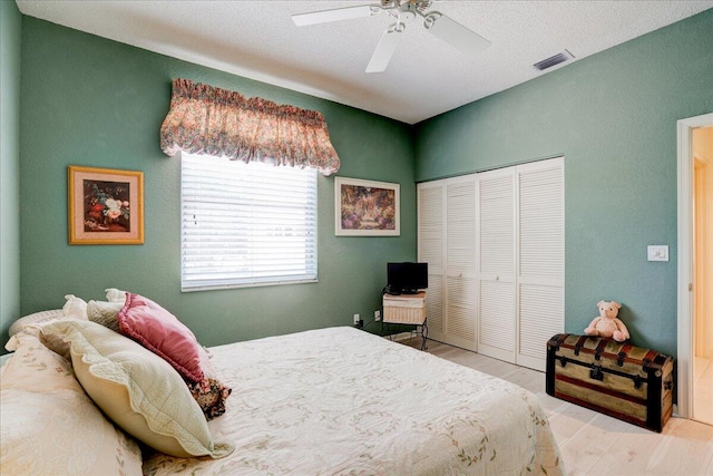 bedroom featuring light hardwood / wood-style floors, a closet, and ceiling fan