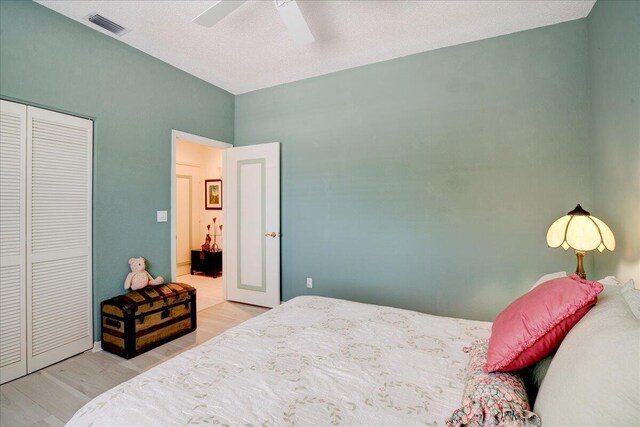 bedroom featuring ceiling fan, light hardwood / wood-style flooring, and a closet