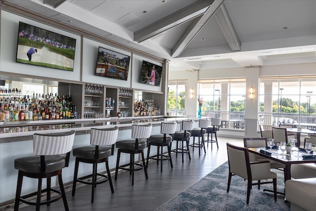 bar with beamed ceiling and dark hardwood / wood-style flooring