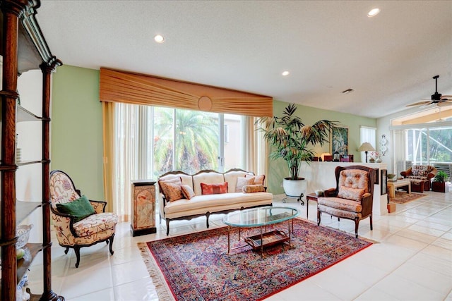 tiled living room with lofted ceiling, a textured ceiling, and ceiling fan