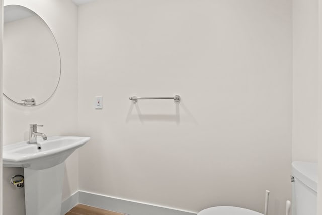 bathroom with wood-type flooring and toilet