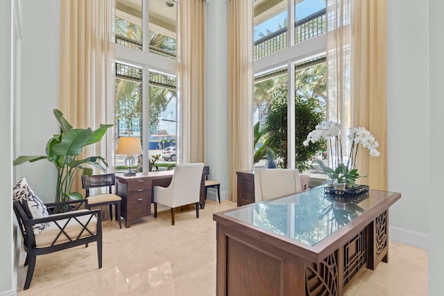 home office with light tile patterned floors and a towering ceiling