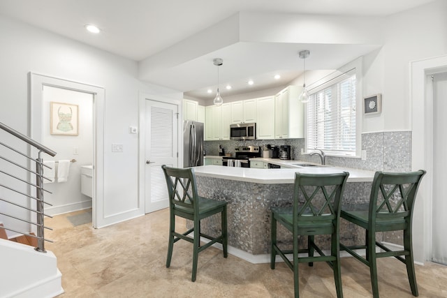 kitchen with a breakfast bar area, kitchen peninsula, backsplash, and stainless steel appliances