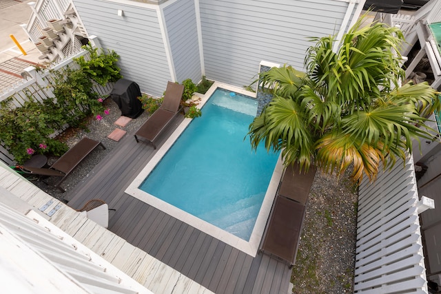 view of swimming pool featuring a wooden deck and grilling area