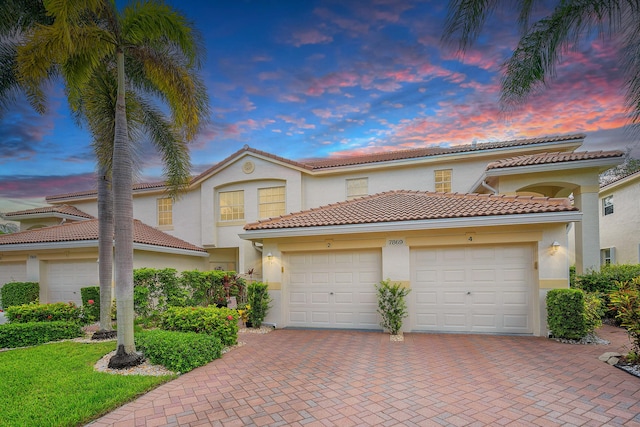7869 Laina Ln Unit 2, Boynton Beach, FL 33437 - view of front of home featuring decorative driveway, an attached garage, stucco siding, and a tile roof