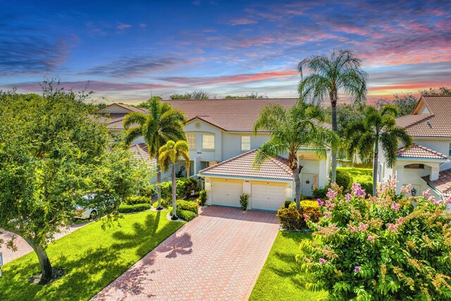 7869 Laina Ln Unit 2, Boynton Beach, FL 33437 - mediterranean / spanish-style home featuring a tiled roof, stucco siding, decorative driveway, a front yard, and an attached garage