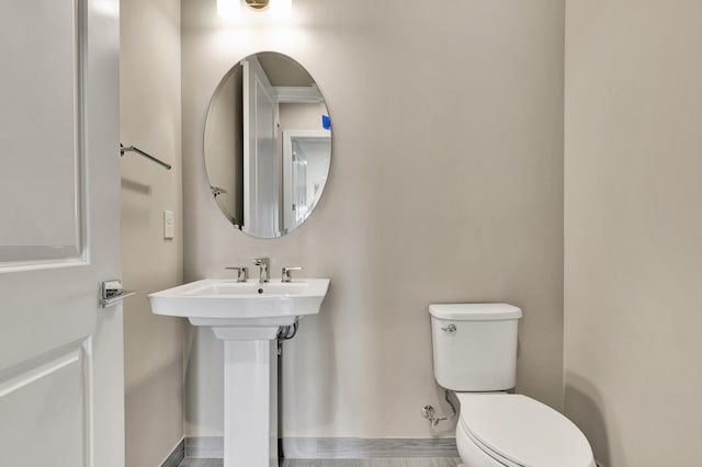 bathroom with hardwood / wood-style floors, toilet, and sink