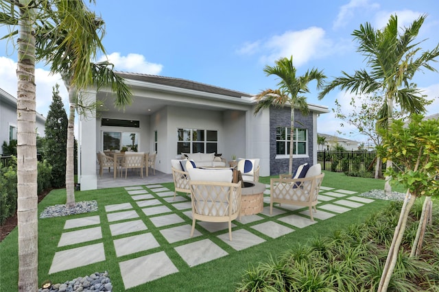 rear view of property with outdoor lounge area, a patio, and a lawn