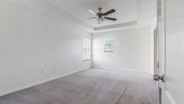 2156 SE Eatonville Dr, Port Saint Lucie, FL 34952 - carpeted spare room with a tray ceiling, baseboards, and a ceiling fan