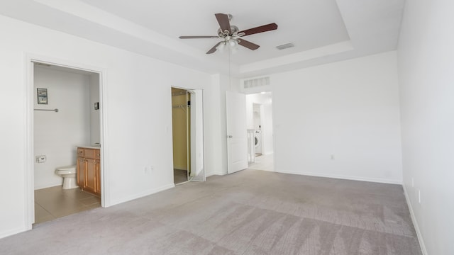 2156 SE Eatonville Dr, Port Saint Lucie, FL 34952 - unfurnished bedroom featuring washer / dryer, visible vents, a raised ceiling, and light carpet