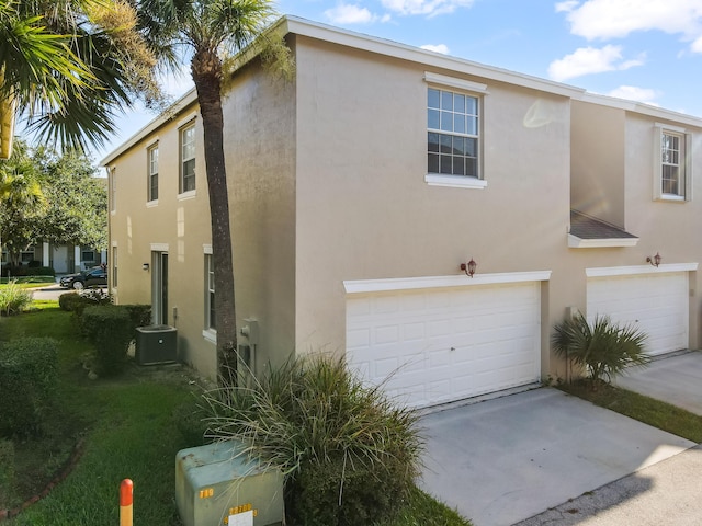 2156 SE Eatonville Dr, Port Saint Lucie, FL 34952 - exterior space featuring central AC, an attached garage, driveway, and stucco siding