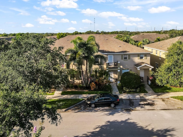 2156 SE Eatonville Dr, Port Saint Lucie, FL 34952 - view of front of home with a balcony, stucco siding, and uncovered parking
