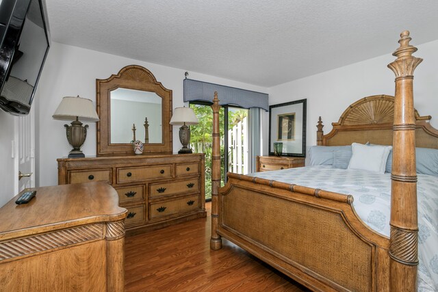 bedroom with dark hardwood / wood-style flooring and a textured ceiling