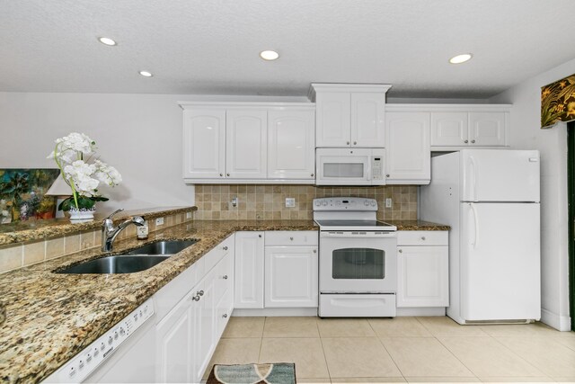 kitchen with white appliances, white cabinets, light tile patterned flooring, and sink