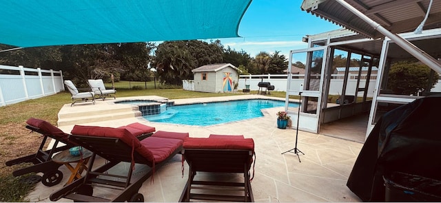 view of pool with a patio and a shed