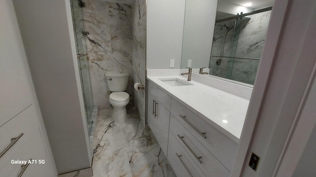 bathroom featuring a shower with door, toilet, and vanity