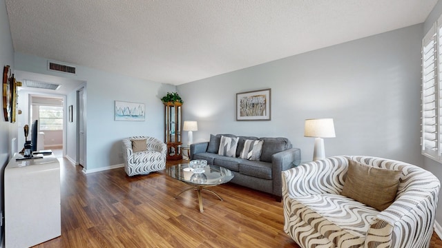 living room featuring a textured ceiling and hardwood / wood-style flooring