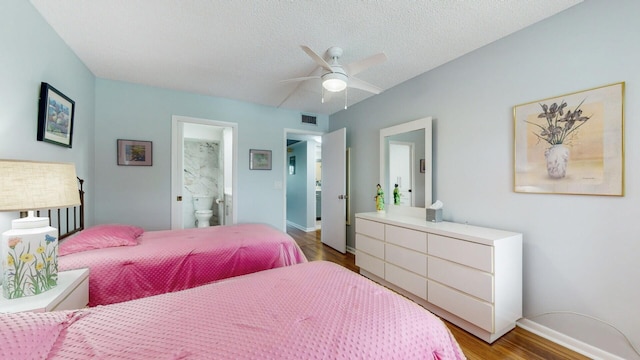 bedroom with a textured ceiling, ceiling fan, ensuite bathroom, and hardwood / wood-style floors