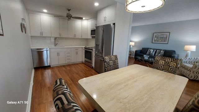 kitchen with dark hardwood / wood-style flooring, sink, stainless steel appliances, and white cabinetry